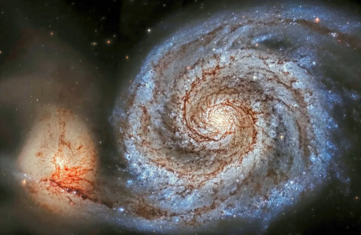 Image of a whirlpool galaxy rendered in blue, cream and orange